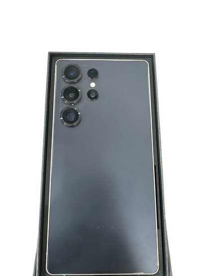 Iphoneio Official Galaxy S25 smartphone in dark grey with a multi-lens camera system inside its retail box