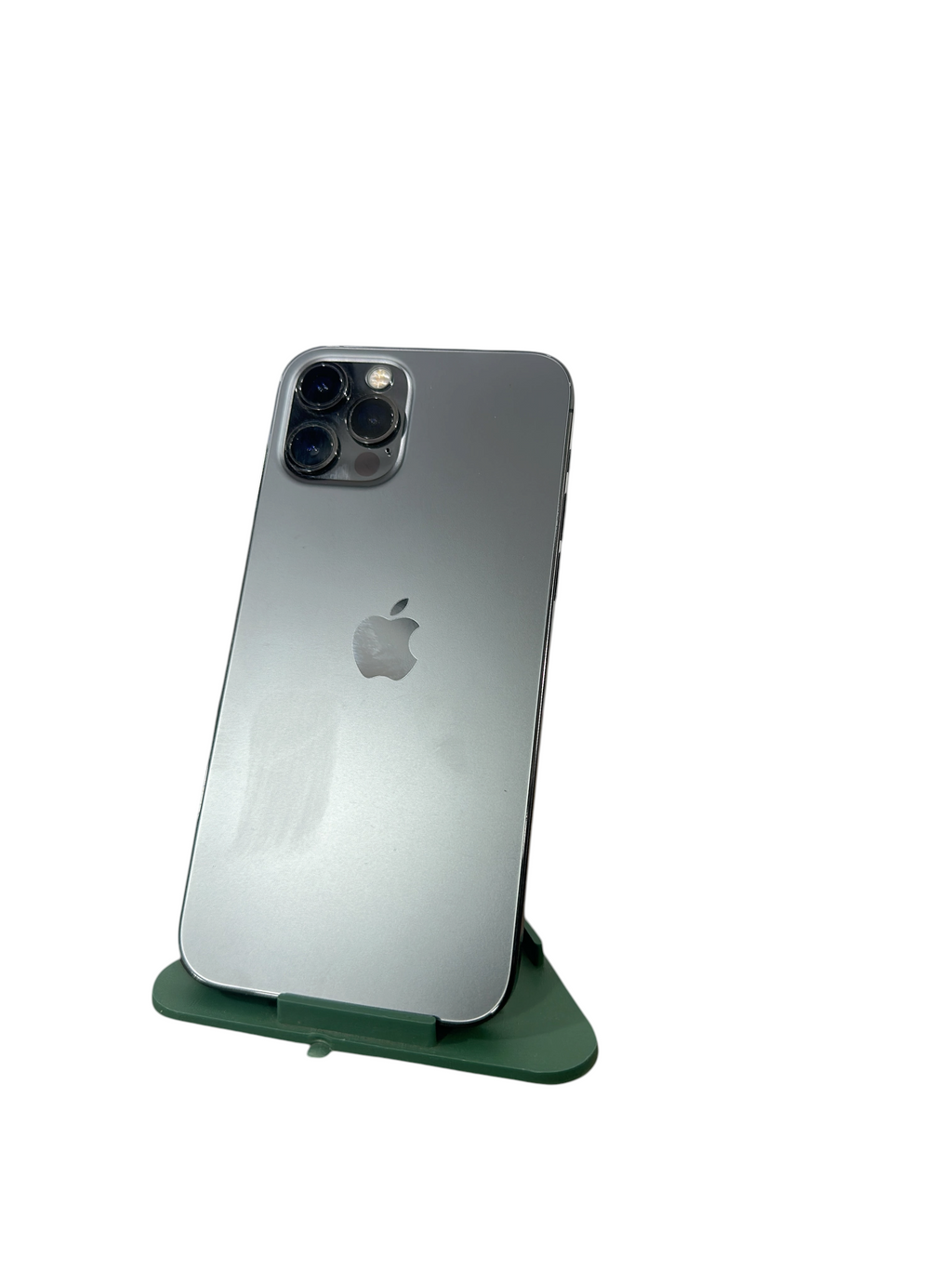Iphoneio Official pre-owned iPhone 12 Pro in silver with a matte glass back and triple-camera system on a green stand.