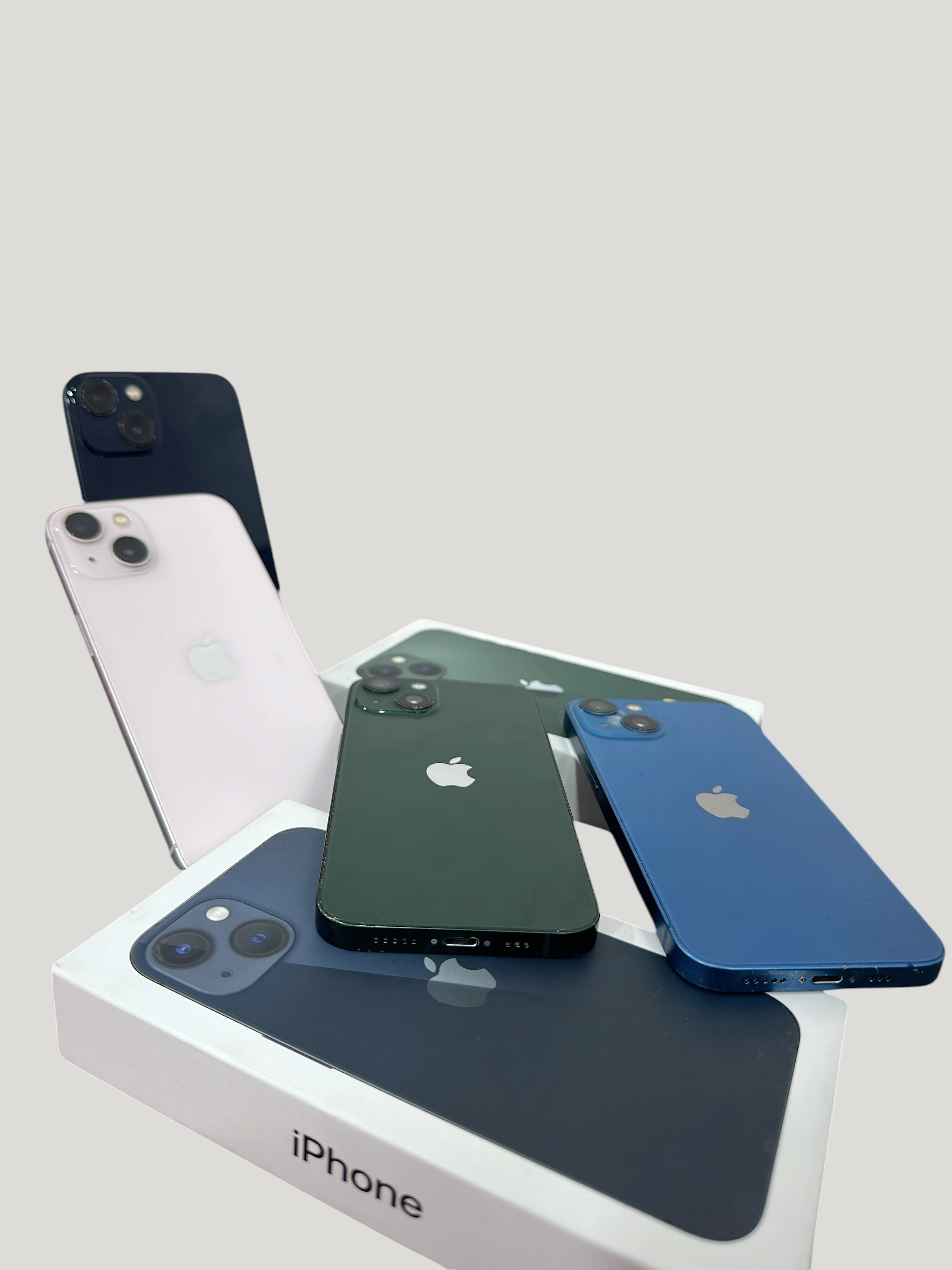 Iphoneio Official collection of Apple iPhone 13 smartphones in various colors with retail boxes on black background