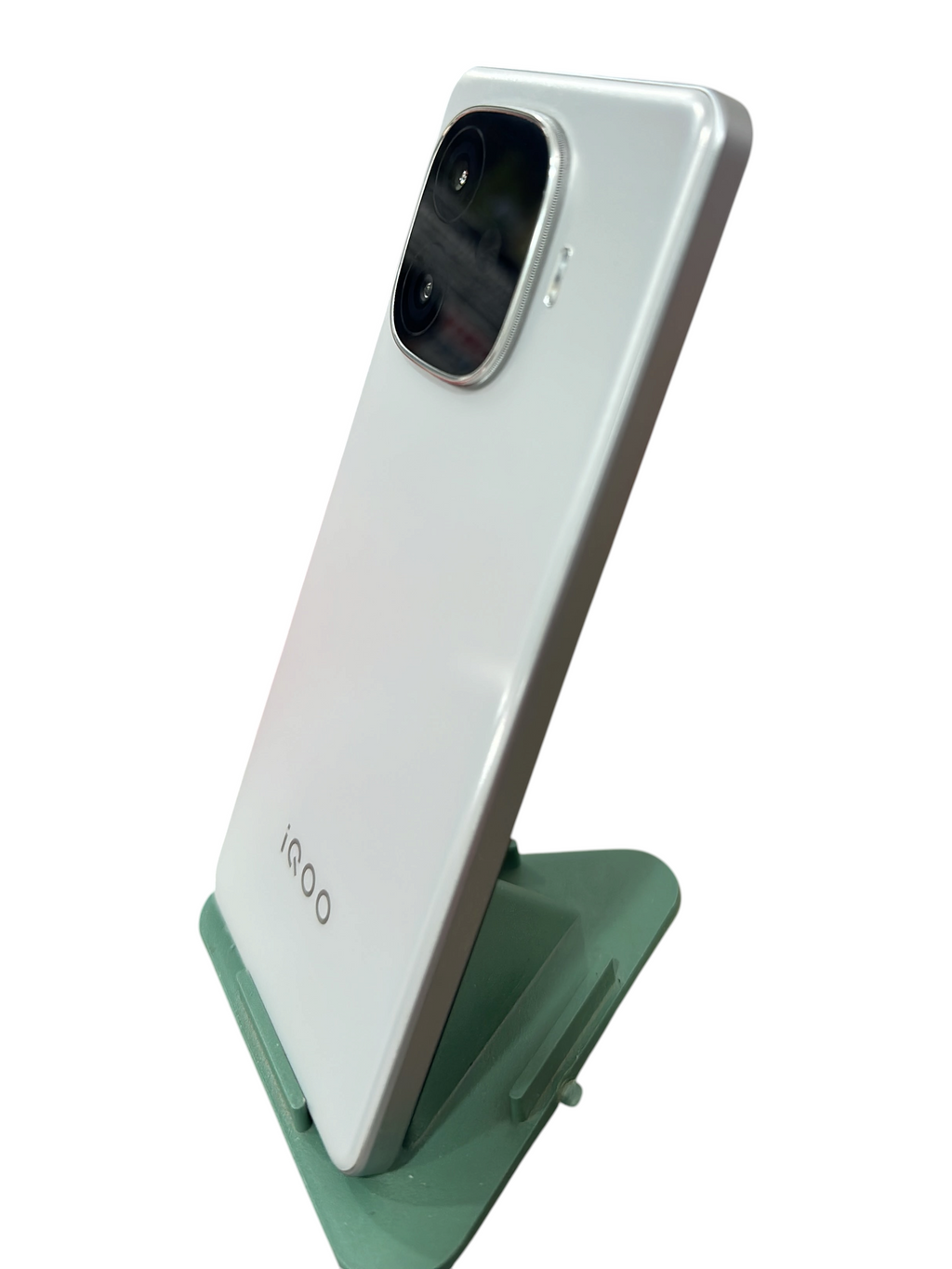 Iphoneio Official iQOO smartphone in pearlescent white with a prominent rear camera module on a green stand