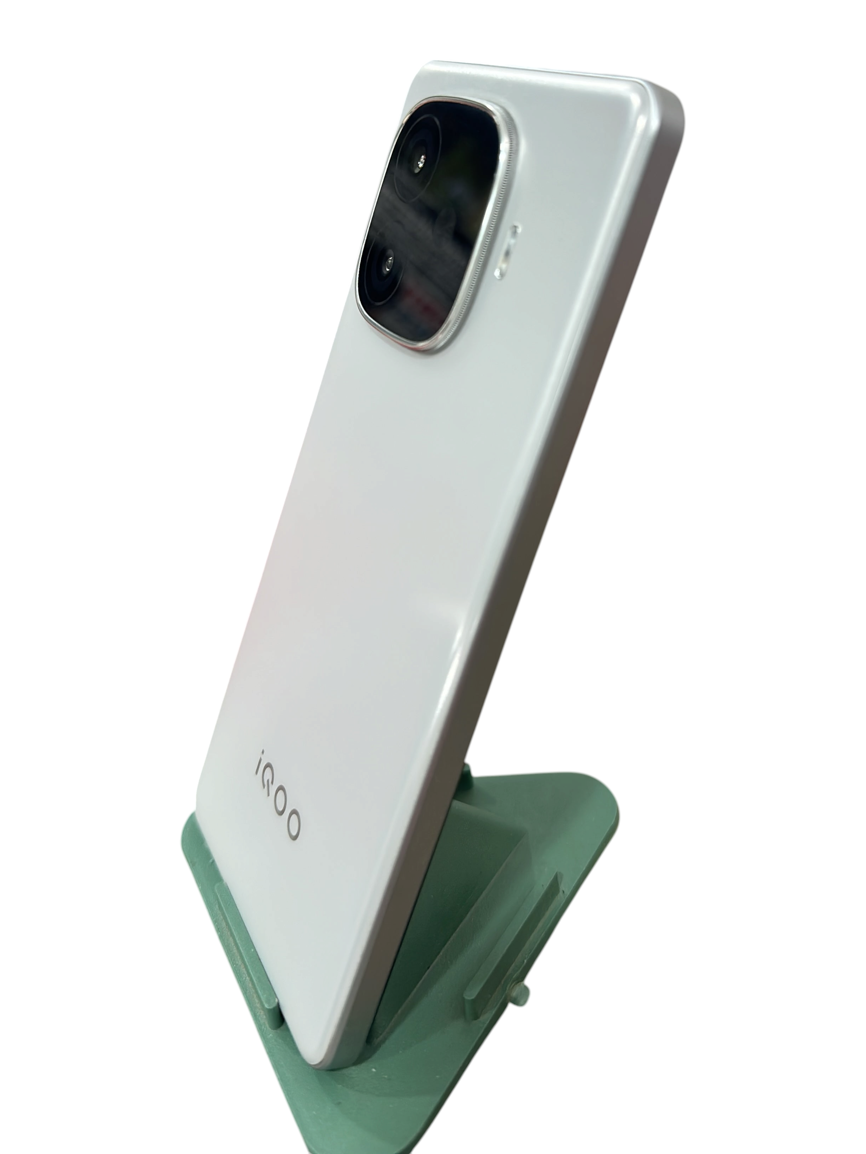 Iphoneio Official iQOO smartphone in pearlescent white with a prominent rear camera module on a green stand