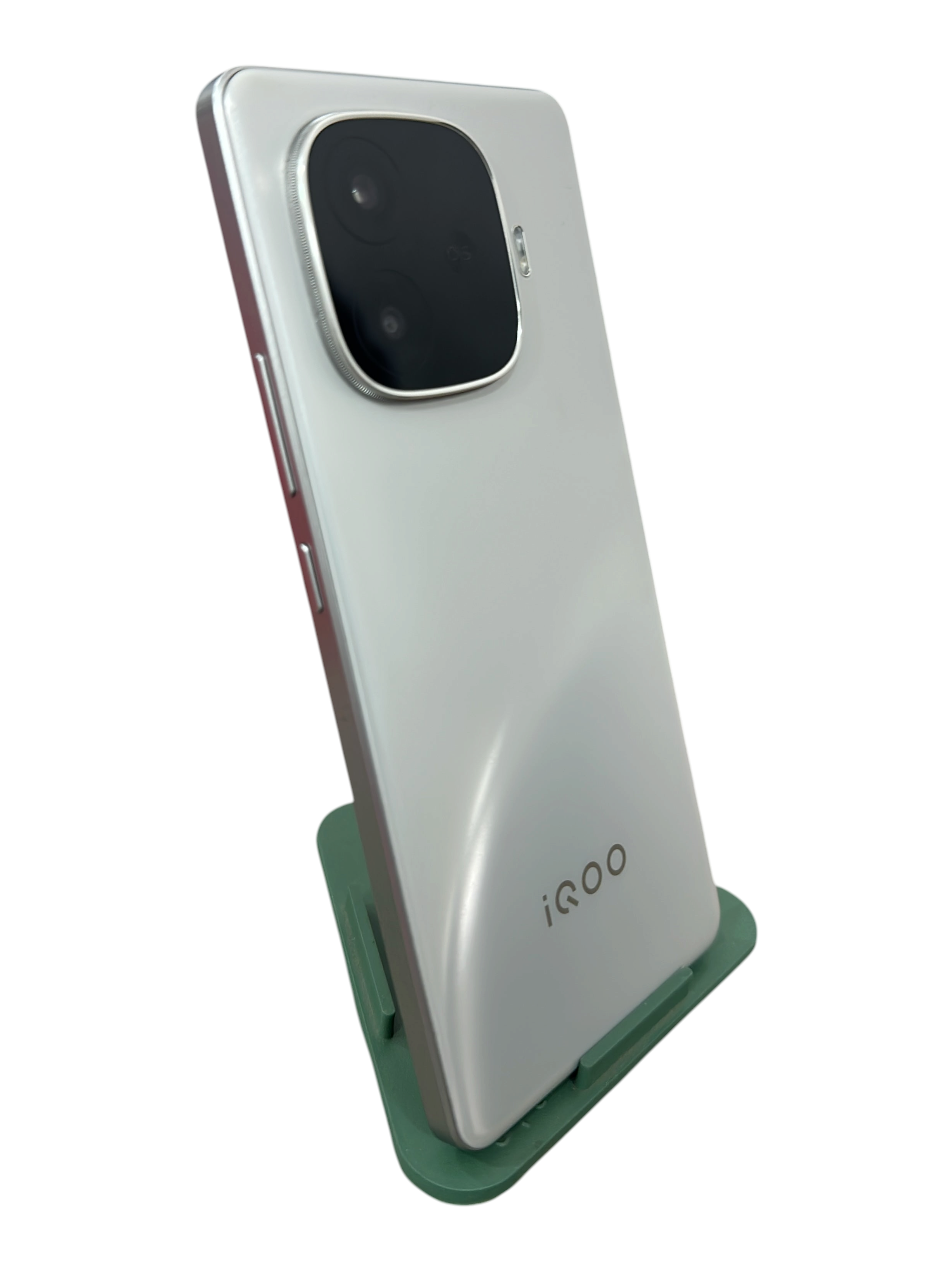 Iphoneio Official iQOO smartphone in pearlescent white with a prominent rear camera module on a green stand.