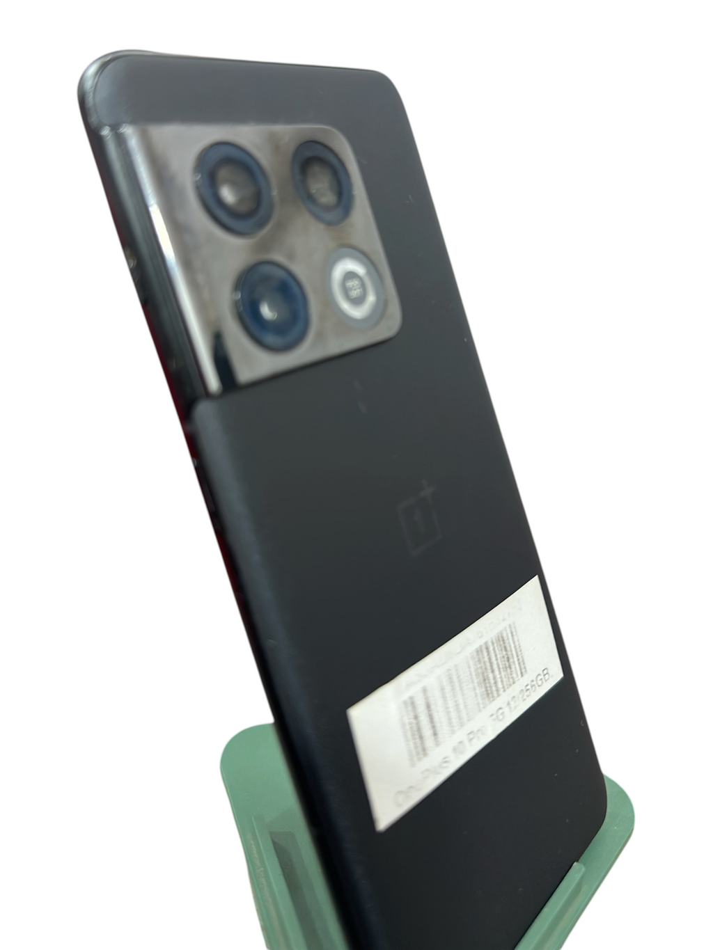 Iphoneio Official OnePlus 10 Pro 5G smartphone in matte black with a triple camera system on a green display stand.