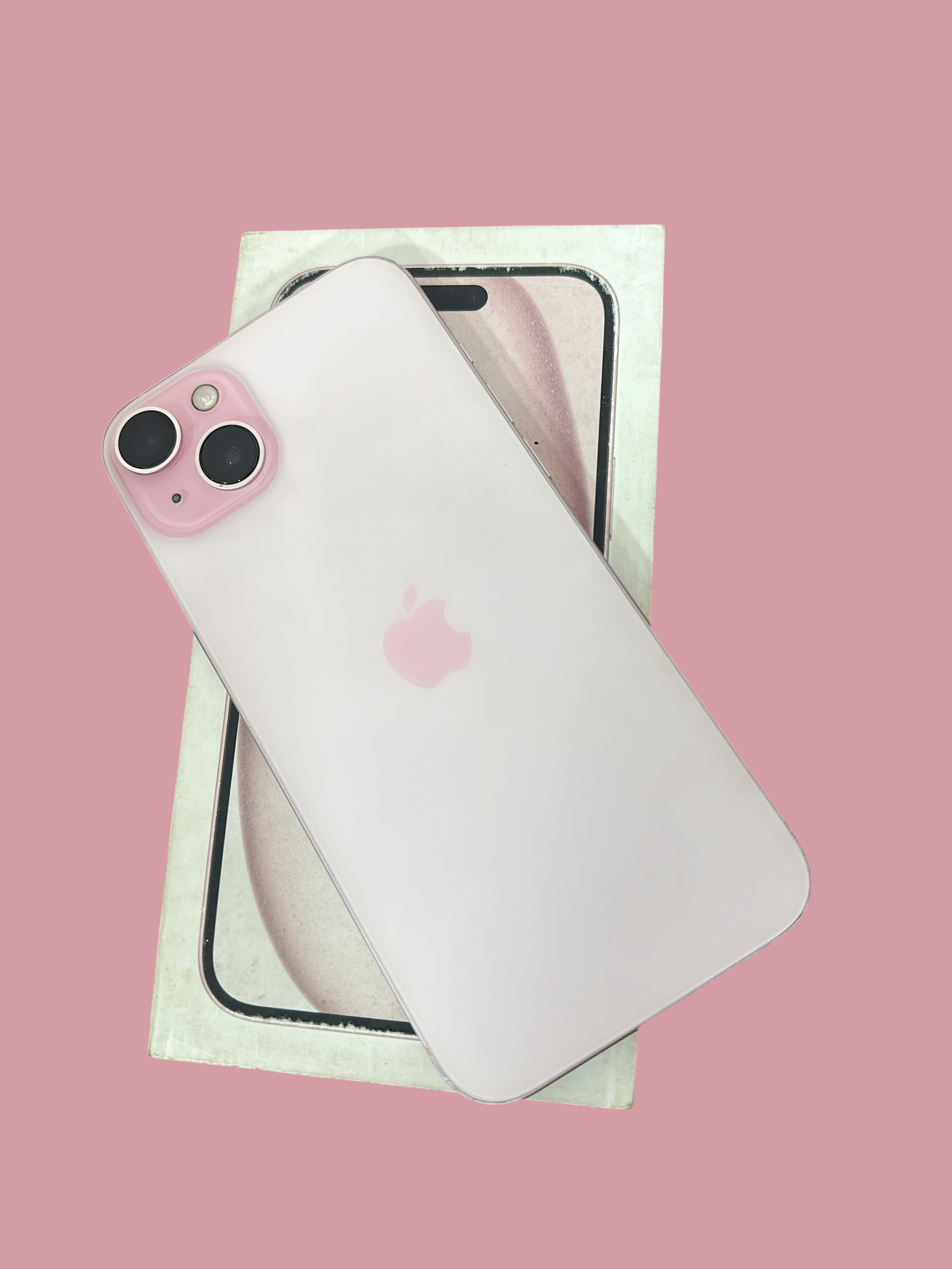 Iphoneio Official Apple iPhone 15 Plus in light pink with dual-camera system resting on its original product box