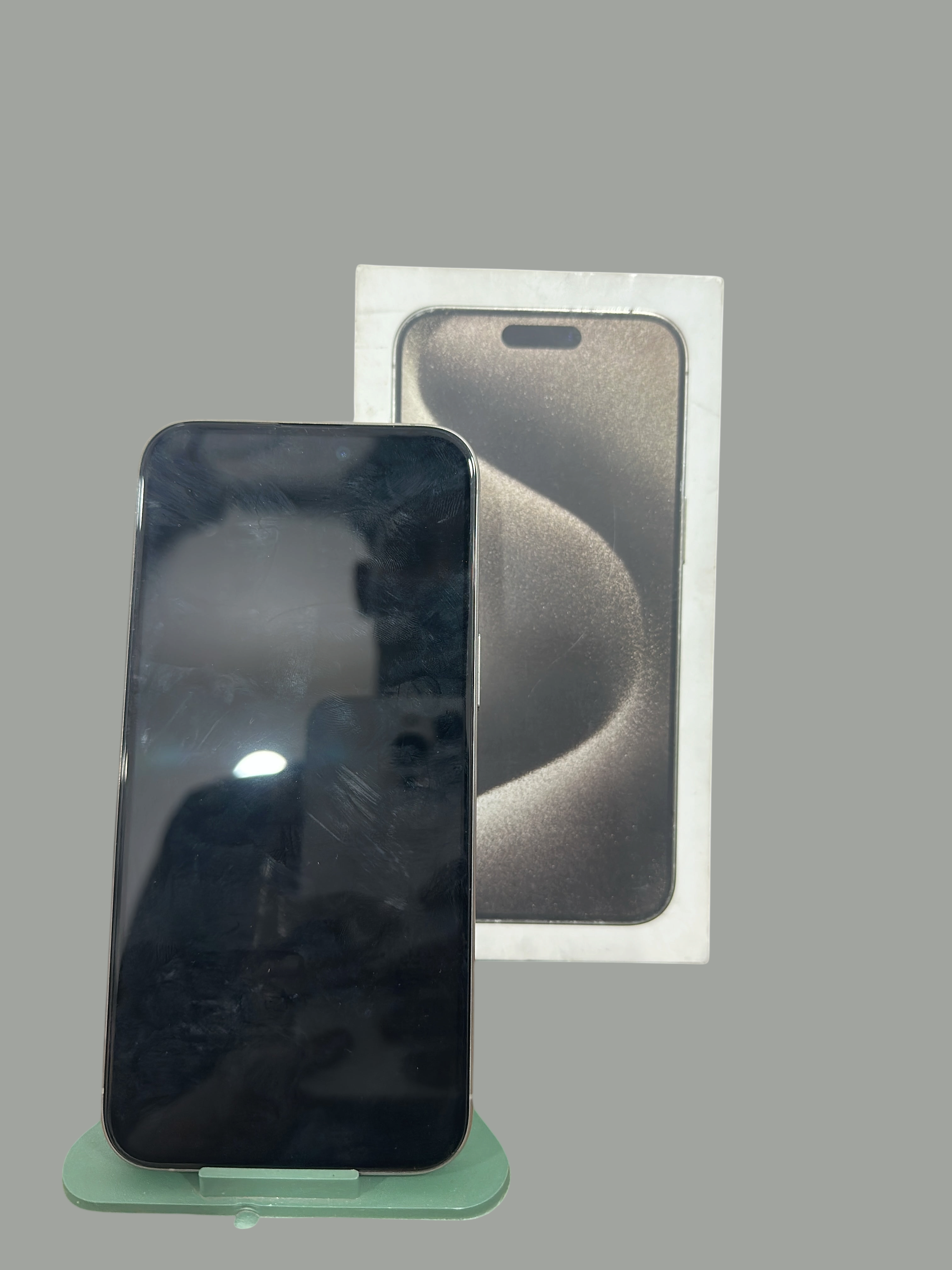 Iphoneio Official premium smartphone with titanium frame and original retail box on a green display stand