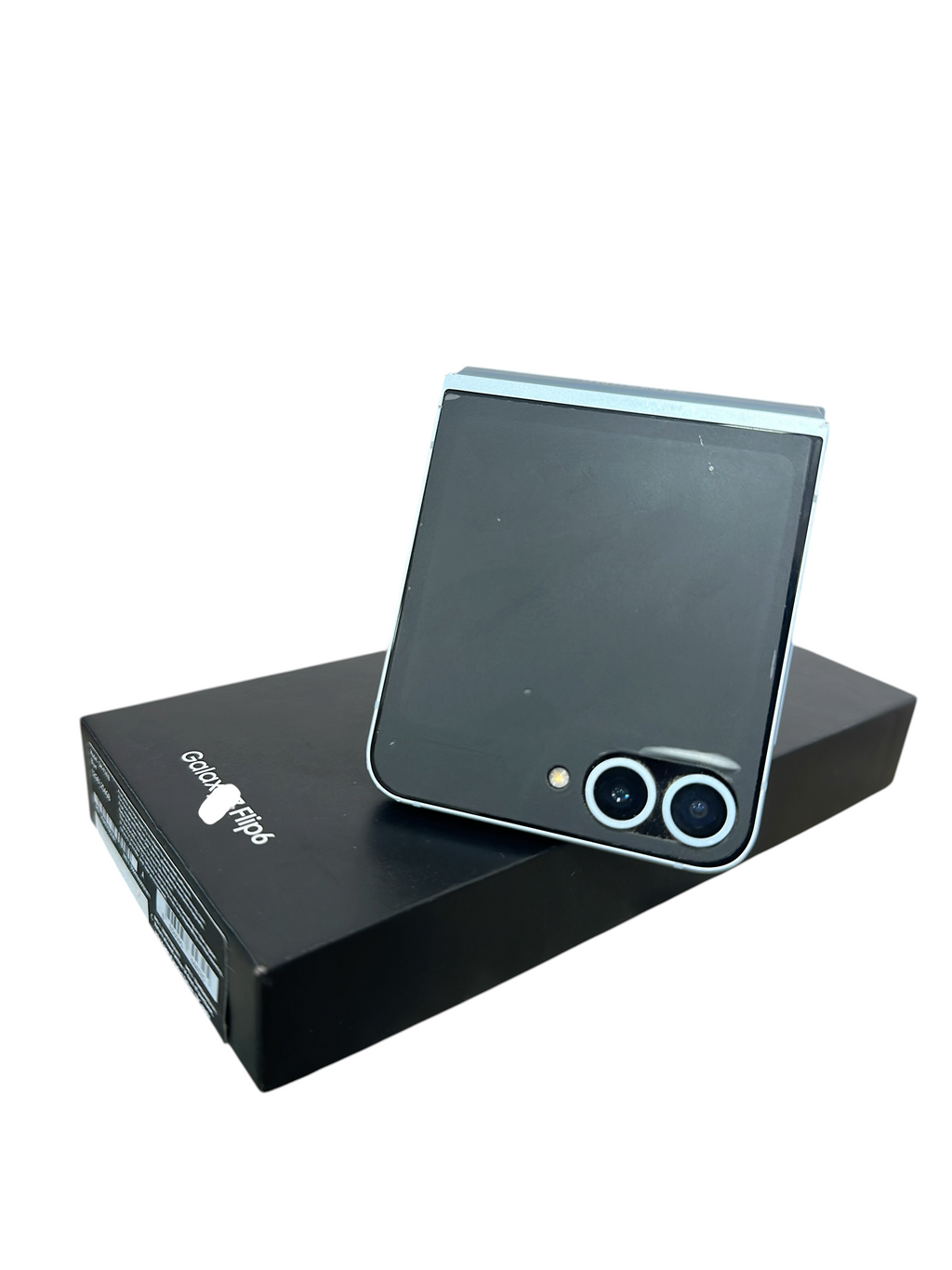 Iphoneio Official Samsung Galaxy Z Flip6 light blue foldable smartphone resting on its black retail box