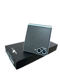 Iphoneio Official Samsung Galaxy Z Flip6 light blue foldable smartphone resting on its black retail box