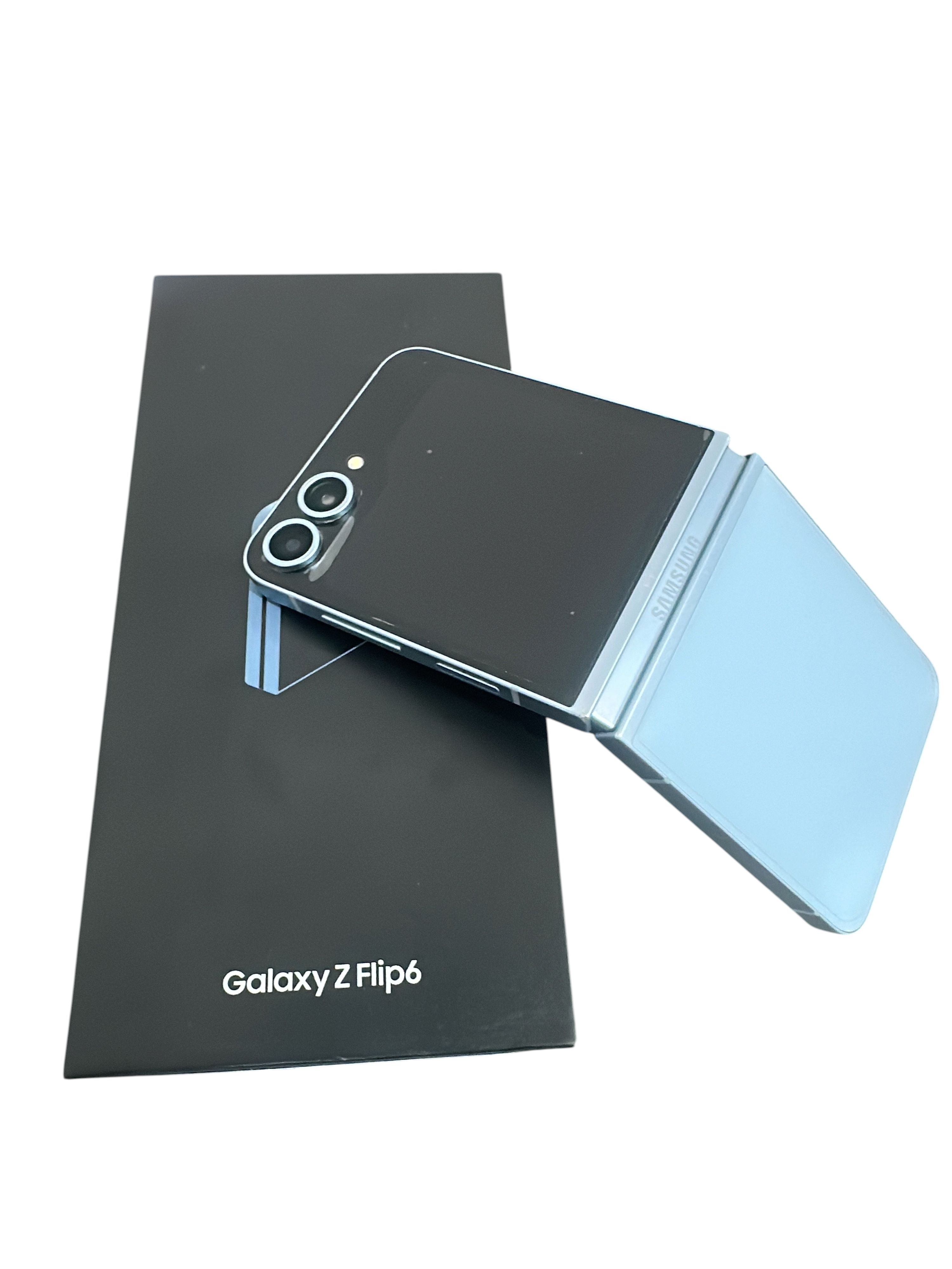 Iphoneio Official Samsung Galaxy Z Flip6 light blue foldable smartphone resting on its black product packaging box