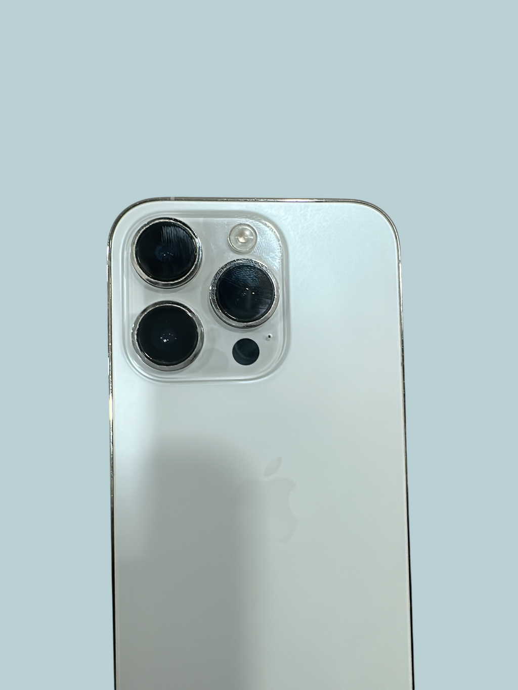 Iphoneio Official silver smartphone featuring a triple-lens camera system on a sleek glass back panel.