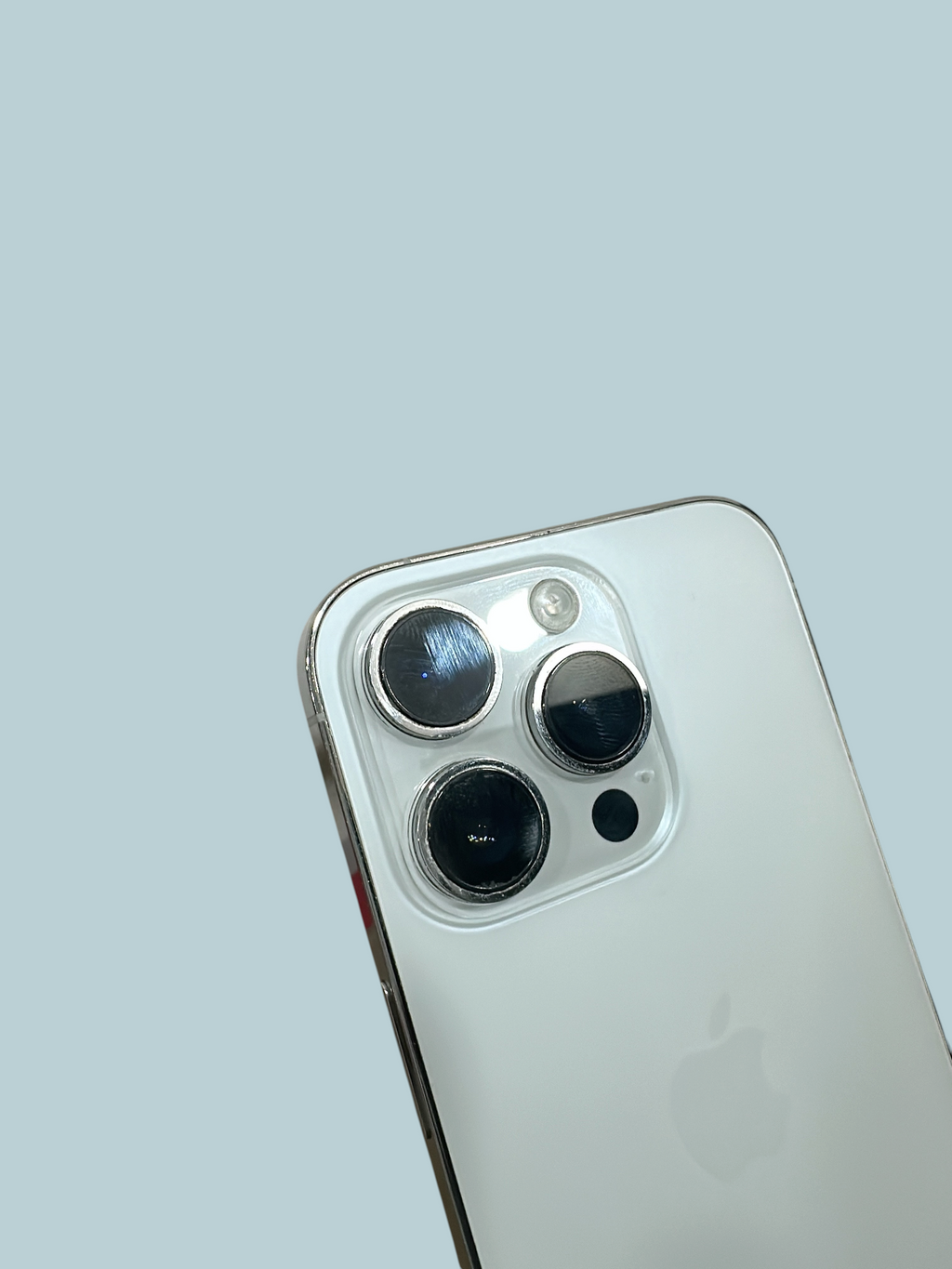 Iphoneio Official silver smartphone featuring a triple-lens camera system on a sleek glass back against black background