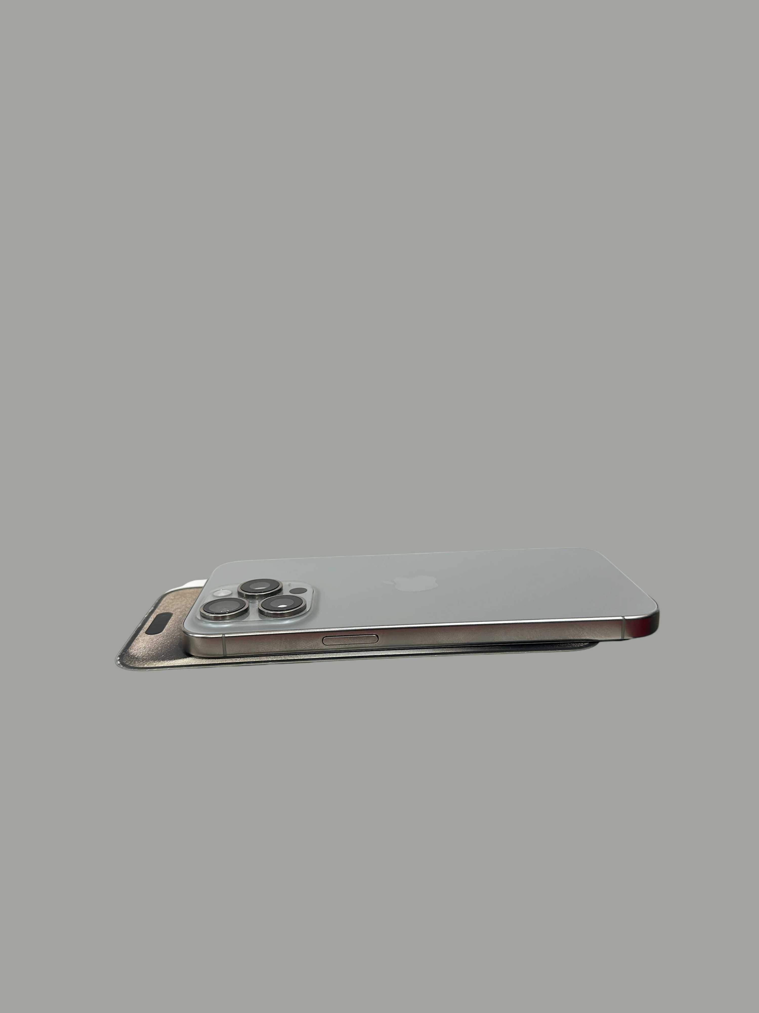 Iphoneio Official premium smartphone with titanium frame and triple-camera system resting on its original white box.
