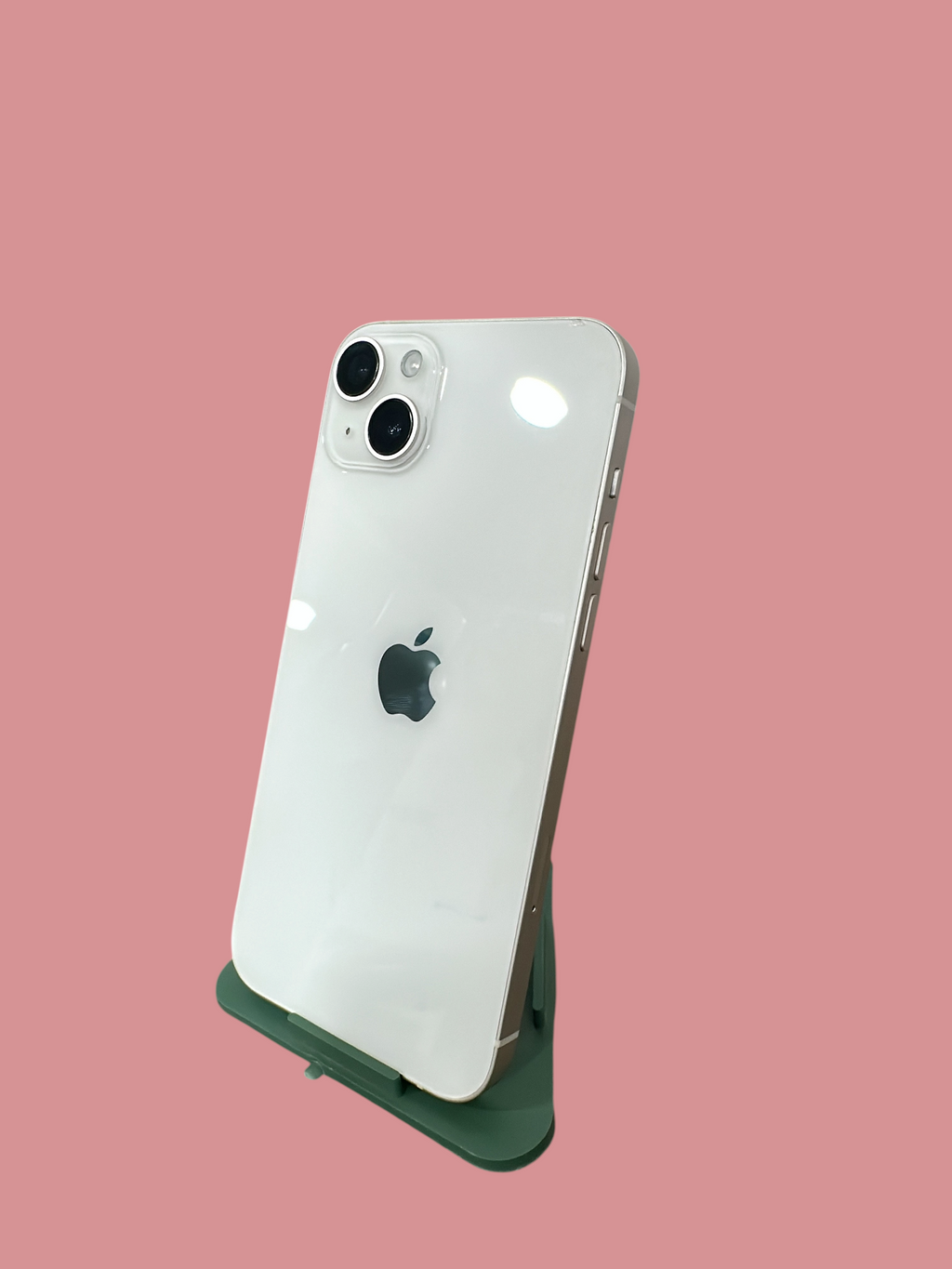 Iphoneio Official white smartphone with a dual-camera system and glass back, displayed on a green stand.